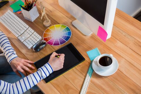 Designer working with colour wheel and digitizer in the office
